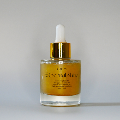 A clear glass bottle with a dropper containing golden yellow shimmer oil, labeled 'Ethereal Shine'.
